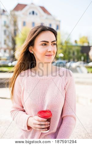 Woman At Fountain With Phone And Coffee To Takeaway On City Street