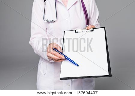 Smiling Doctor Woman With Documents And Pen For Your Signature On Grey