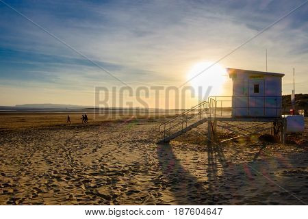 Lifeguard house at sunset in spring at low tide on Camber Sands beach, East Sussex, England, UK