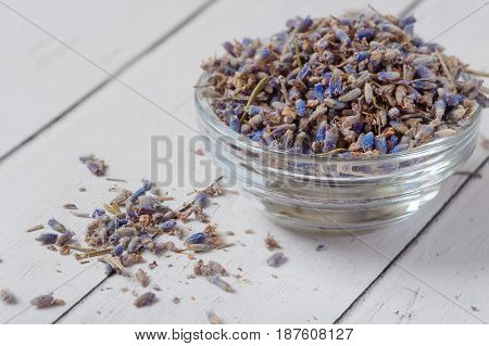 glass bowl with lavender petals and a bouquet of dry lavender