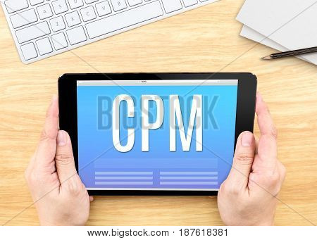 Hand Holding Tablet With Cpm (cost Per Mille)  Word On Wood Table ,internet Marketing Concept.