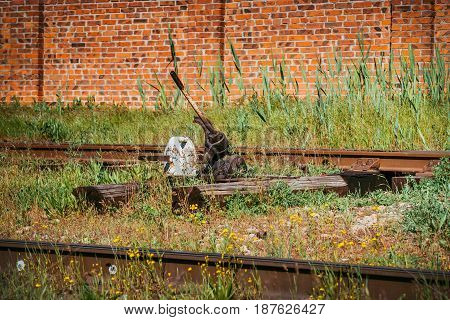 Railroad switch, turnout. Railroad switch of the old train station. Old rusty railroad switch with counterweight, manually (hand) operated, shallow depth of field.