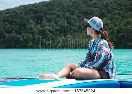 Side View. Asia Woman Sitting Alone On Prow And Looking Scenery Sea View With Green Forest On Island