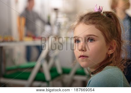 Little girl in a kitchen is looking for
