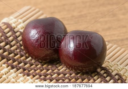 Fresh Fruits Two Ripe and Sweet Red Plums on A Wooden Mat Plate Very Good Source of Vitamin C.