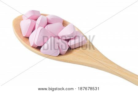 Healthcare Concept Wooden Spoon Full with Vitamins Pills isolated on a White Background.