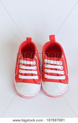 Red sneakers Baby shoes for newborns on isolated background