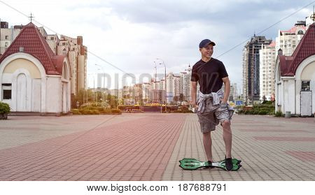 Young man with a skateboard on the street of a big city