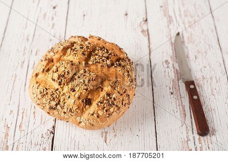 Fresh Seedy Bread With Knife On A White Wooden