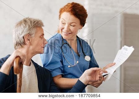 What do you mean by that. Excited graceful intelligent doctor explaining some details of the treatment procedure while conducting a consultation and helping her patient recovering