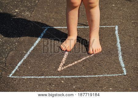 Children's legs on a asphalt road in summer