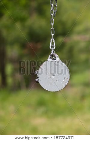Target for training shooting. Metal on the chain.