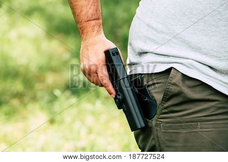 Pistol in the holster. The shooter trains. Is preparing to shoot at the target.