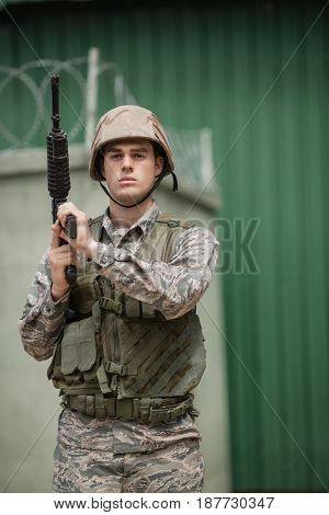 Military soldier standing with a rile in boot camp