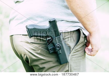 Pistol in the holster. The shooter trains. Is preparing to shoot at the target.