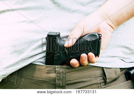 Pistol in the holster. The shooter trains. Is preparing to shoot at the target.