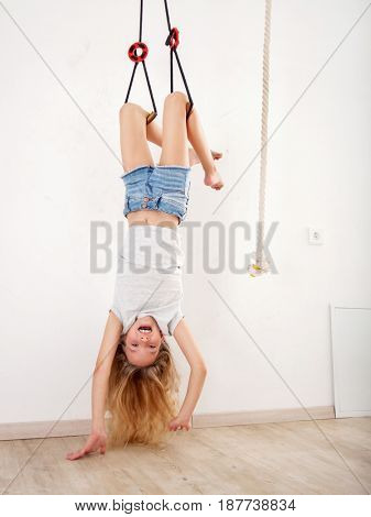 Girl on the wall bars. Child at wall bars do sport exercises