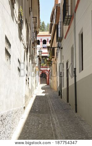 Charming narrow alley in the quarter of Albayzin in Granada Andalusia Spain.