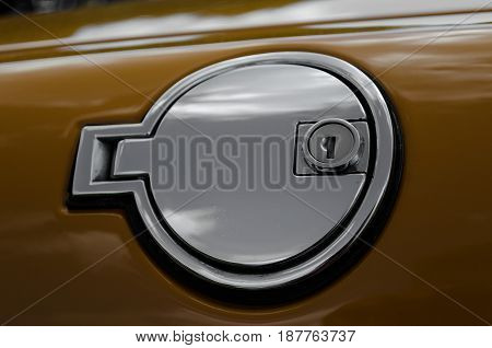 A chrone lockable fuel filler cap on an older classic vintage car