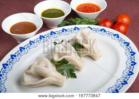 Traditional georgian hinkali dish with herbs and sauces