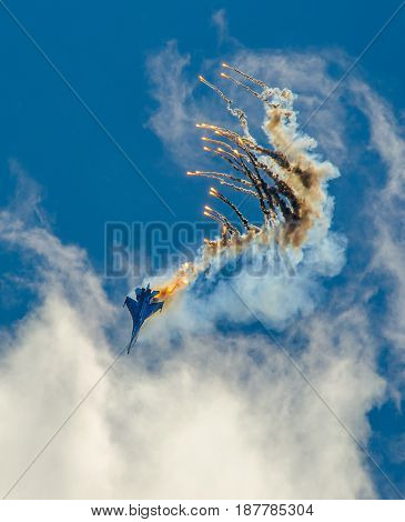 Military aircraft fighter SU-27 nose-dive, performs the maneuver with the ejection of heat missiles