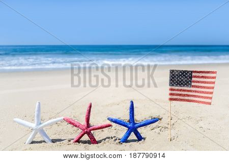 Patriotic USA background with starfishes and american flag on the sandy beach