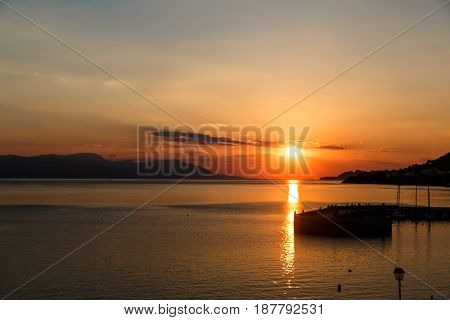 Sun setting down over the sea, The red disc of the sun touches the horizon.