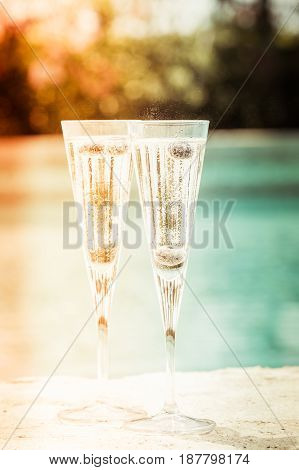 Two Glasses Of Prosecco  Cocktail With Blueberries At The Edge Of A Resort Pool. Concept Of Luxury V