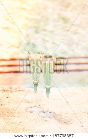 Two Glasses Of Prosecco   At The Edge Of A Resort Pool. Concept Of Luxury Vacation