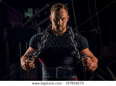Handsome Athlete With A Chain Around His Neck Stands In The Gym