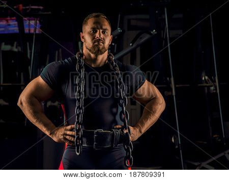 Handsome Athlete With A Chain Around His Neck Stands In The Gym