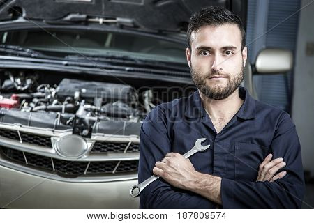 Car Mechanic Man At The Garage Fixing The Engine