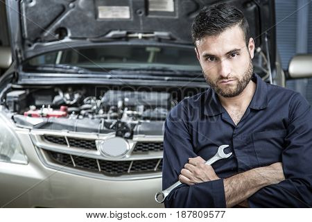Car Mechanic Man At The Garage Fixing The Engine