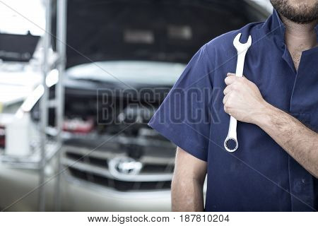 Car Mechanic Man At The Garage Fixing The Engine
