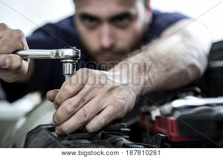 Car Mechanic Man At The Garage Fixing The Engine
