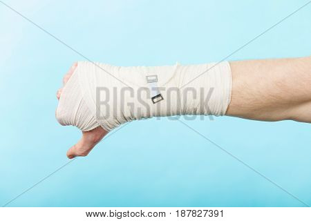 Bad news and information. Medicine aspects. Male hand with bandage showing thumb down sign symbol.