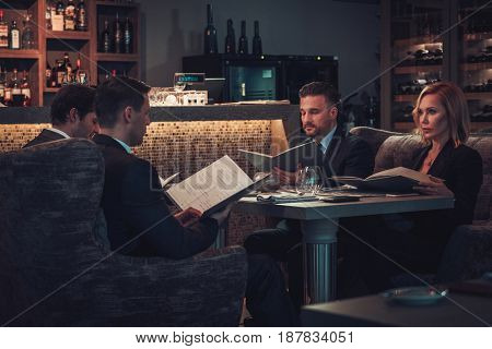 Friends rading menu in a restaurant.