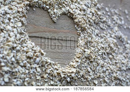 Many brown cereals in heart form are on the wooden background
