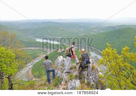 Hikers on top of a mountain enjoy the beautiful view of nature, forest and river in valley. View on meanders of Morava river  from Kablar, Serbia