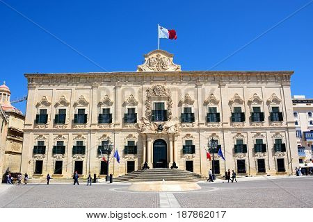VALLETTA, MALTA - MARCH 30, 2017 - View of the Auberge de Castille in Castille Square with tourists enjoying the setting Valletta Malta Europe, March 30, 2017.