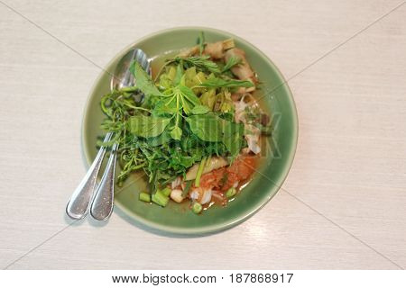 Thai Noodles (Kanom jeen) in a green dish on a food table.