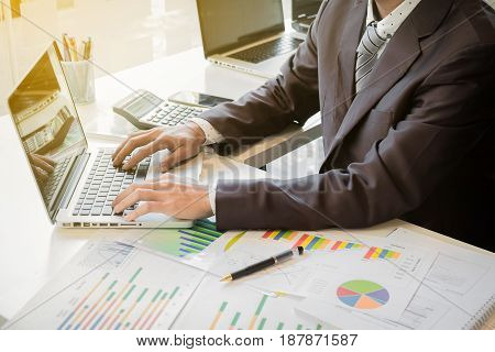 Close up of hand of business man working document and laptop in office morning light. business concept.