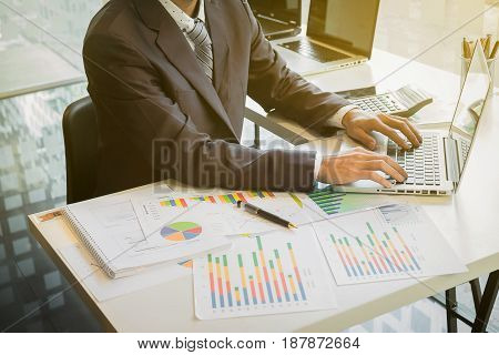 Close up of hand of business man working document and laptop in office morning light. business concept.