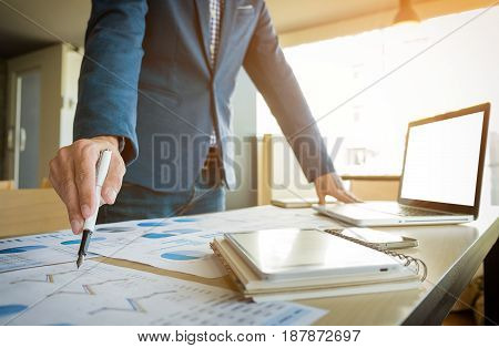 Close up of hand of business man working document and laptop in office morning light. business concept.