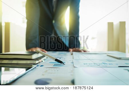 business man working with many document graph and laptop on his desk in morning light. business concept.