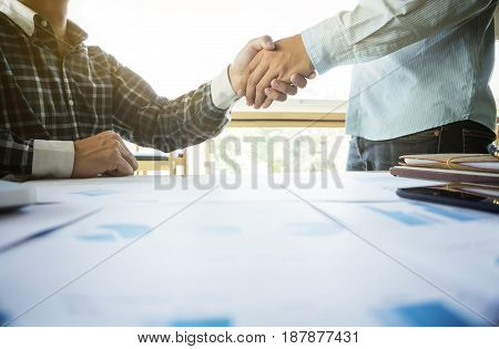Two businessmen shaking hands during a meeting in the office success dealing greeting & business partner.
