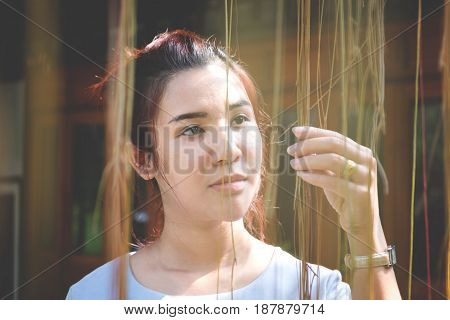 portrait of confident flirting woman with sexy looking creep plant in hands under sunlight