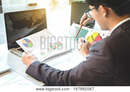 Business team two colleagues discussing new plan financial graph data on office table with laptop and digital tablet.
