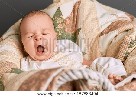 Caucasian baby yawning. Small child with mouth open. Tired signs in infant.