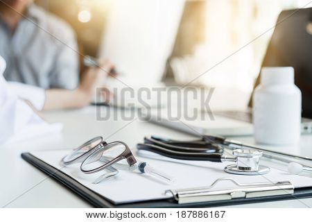 Healthcare and Medical concept patient listening intently to a female doctor explaining patient symptoms or asking a question as they discuss paperwork together in a consultation.